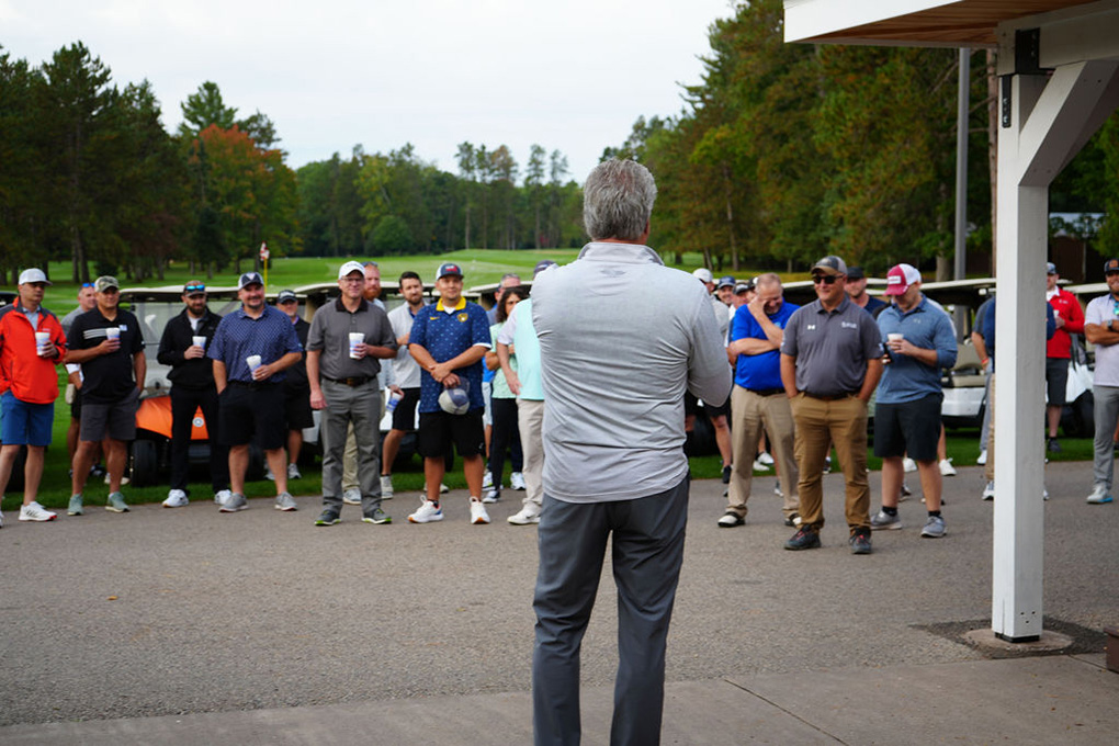 Tom Nagy in front of sponsors of Driving for a Difference fundraiser